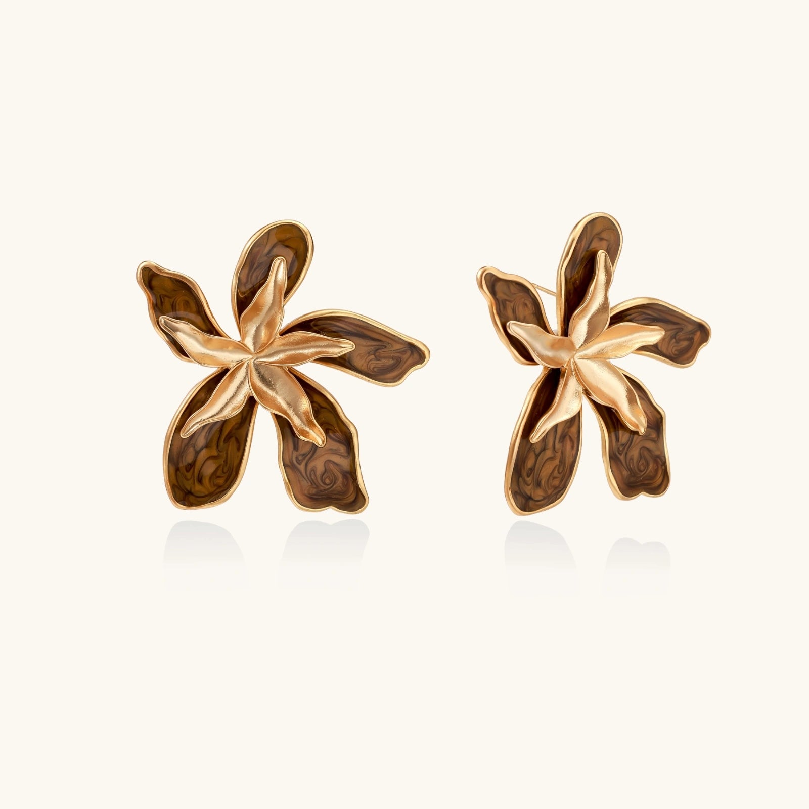 Pair of gold and brown floral earrings on a white background