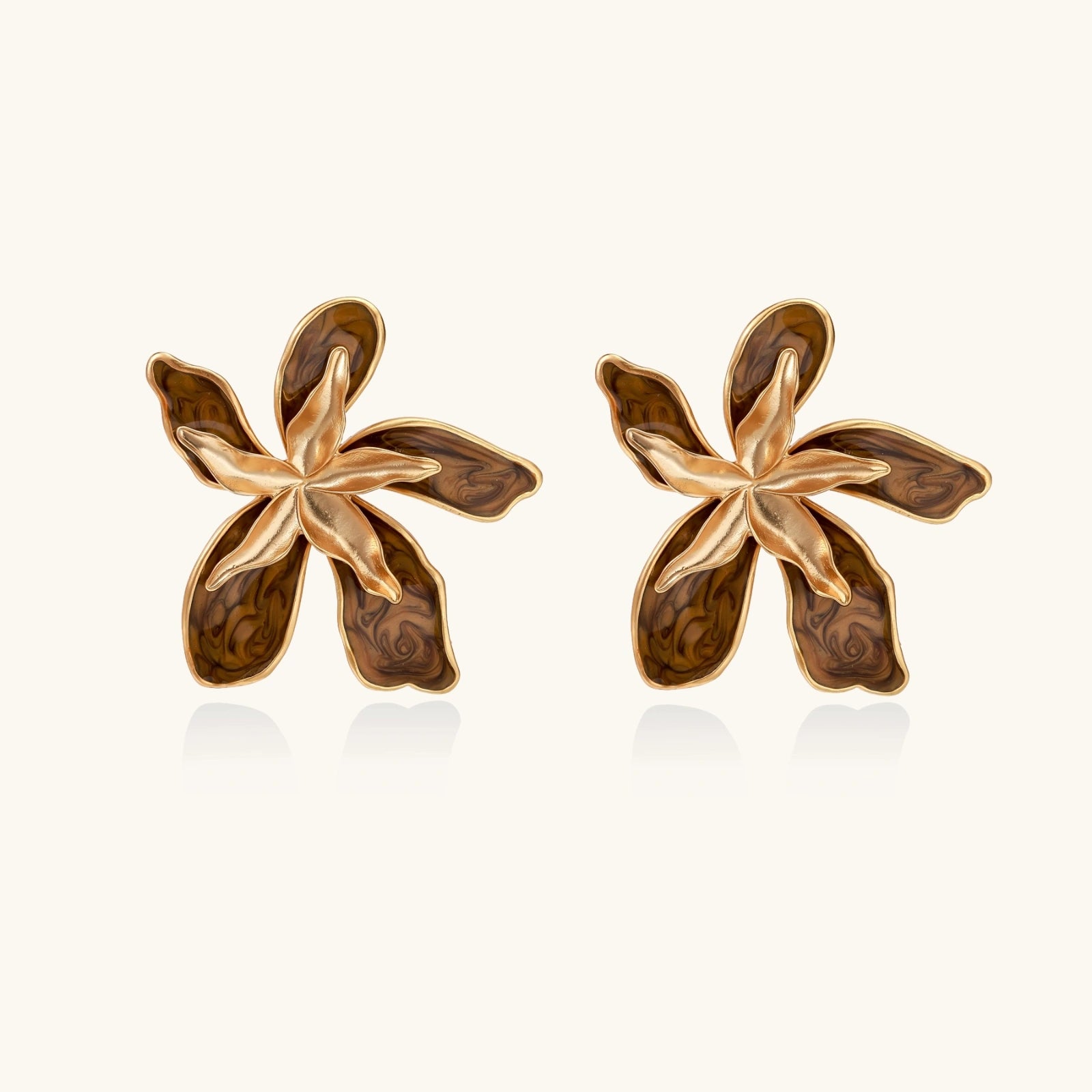 Pair of gold and brown floral earrings on a white background