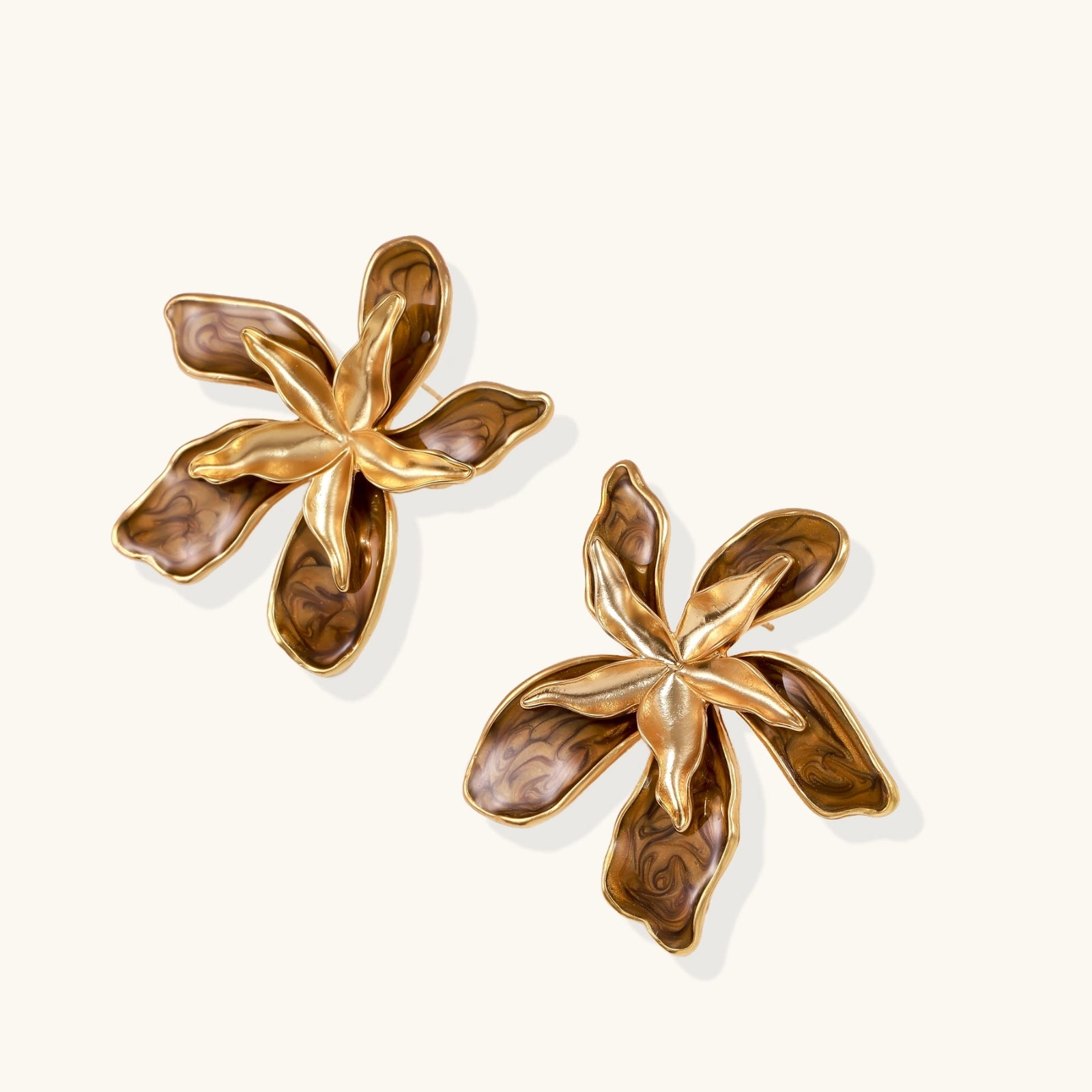 Pair of gold flower-shaped earrings on a white background