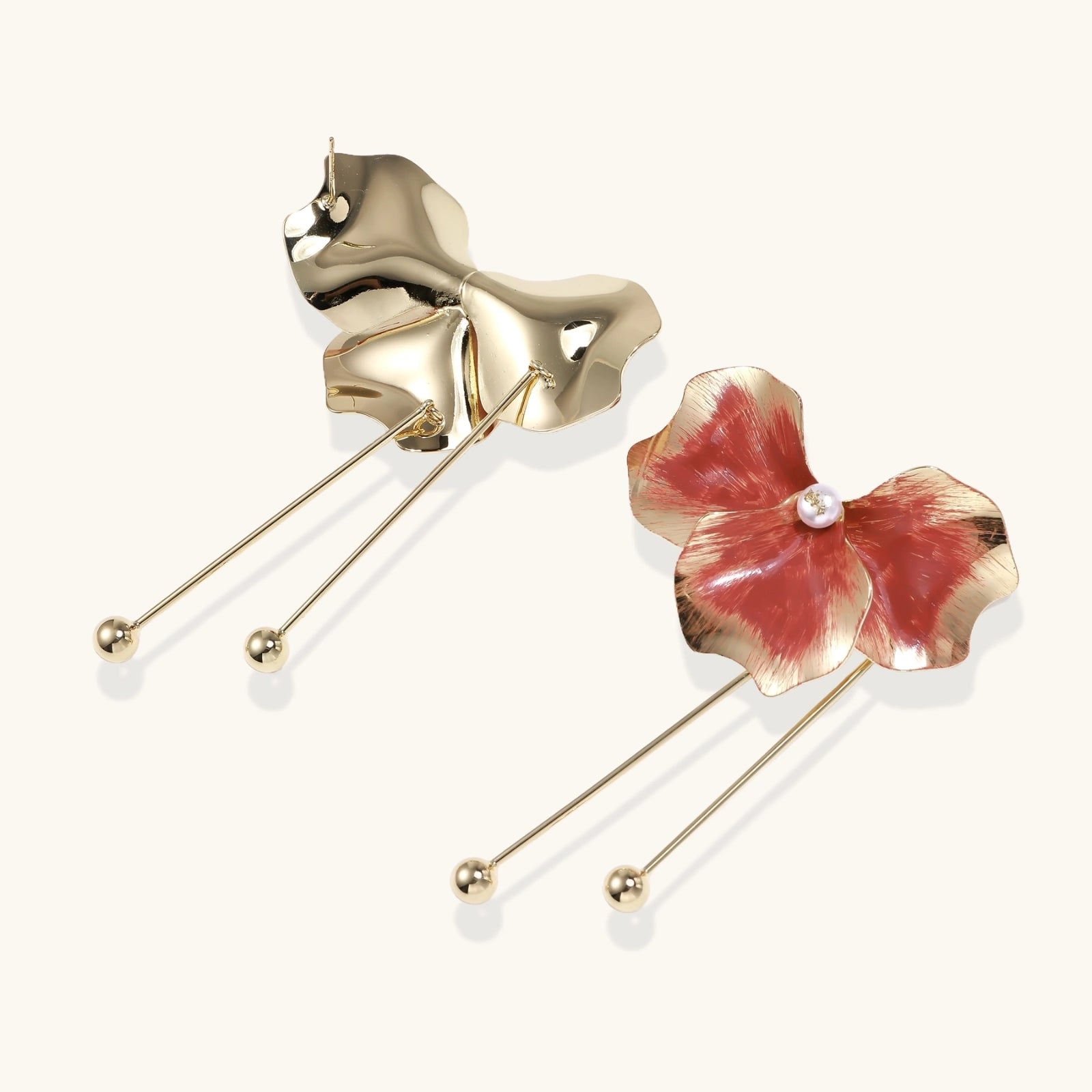 Gold and red floral brooches on a white background