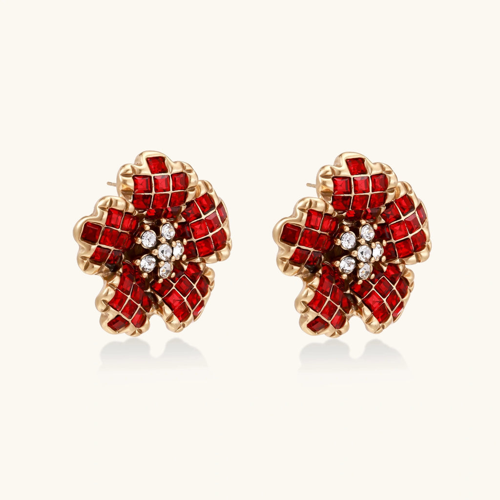 Pair of red and gold earrings on a white background