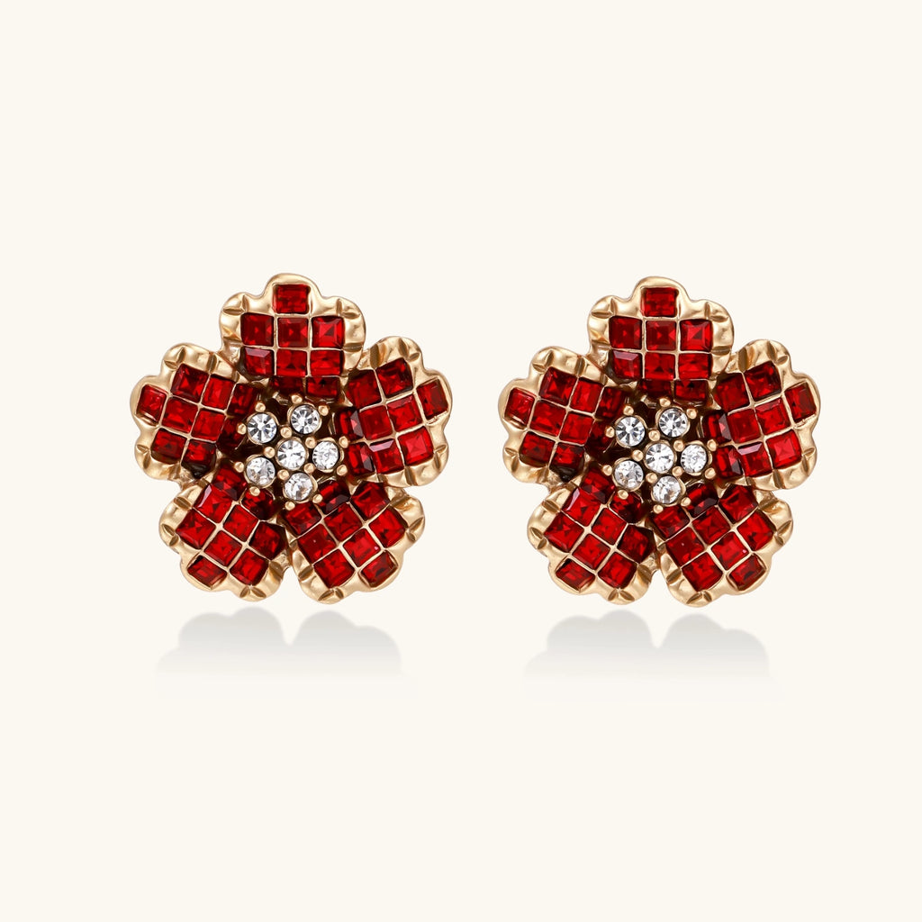 Pair of red flower-shaped crystal earrings with gold accents on a white background