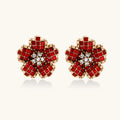 Pair of red flower-shaped crystal earrings with gold accents on a white background