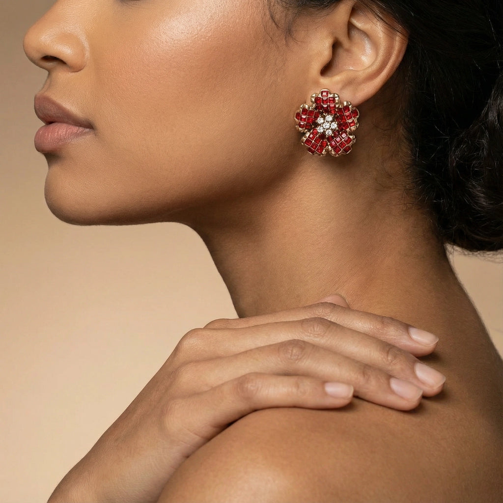Close-up of a woman wearing red floral earrings with a neutral background