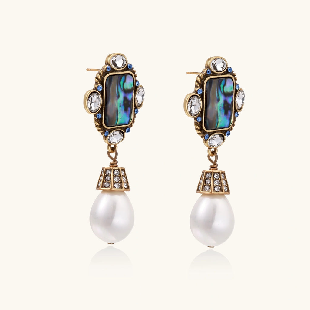 Pair of ornate earrings with pearl drops on a white background