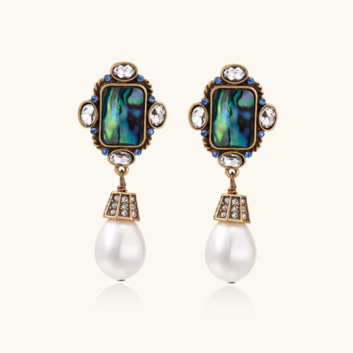 Pair of ornate earrings with gemstones and pearls on a white background