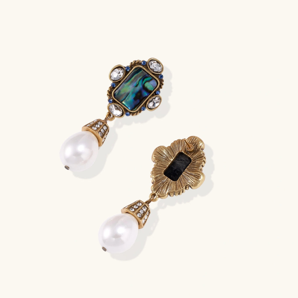 Ornate earring with pearls and gemstones on a white background