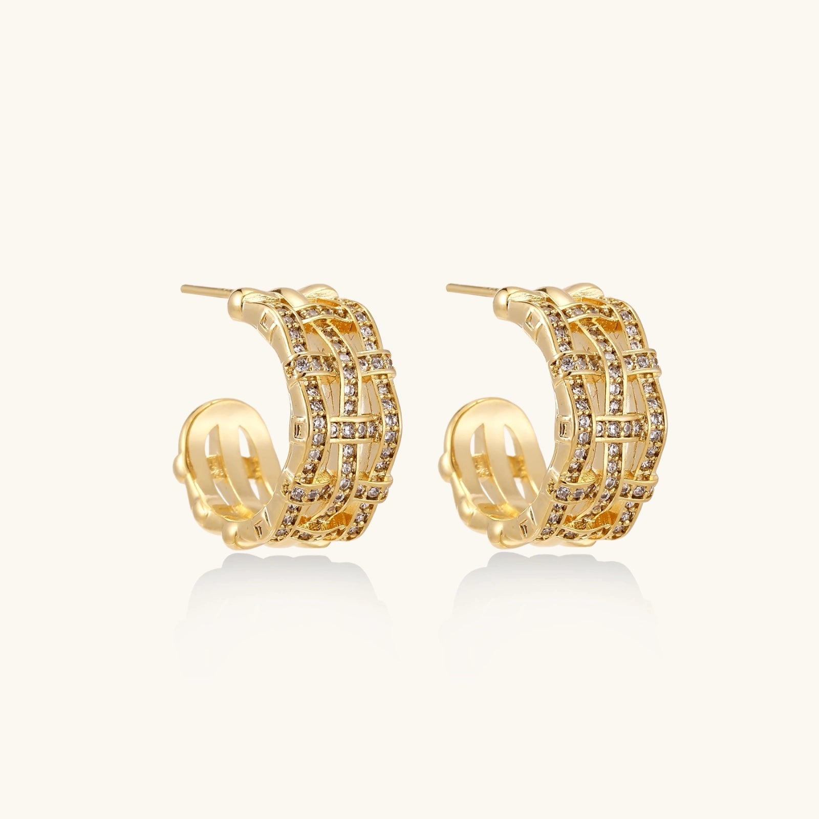 Gold hoop earrings with basket weave design and embedded stones on a white background