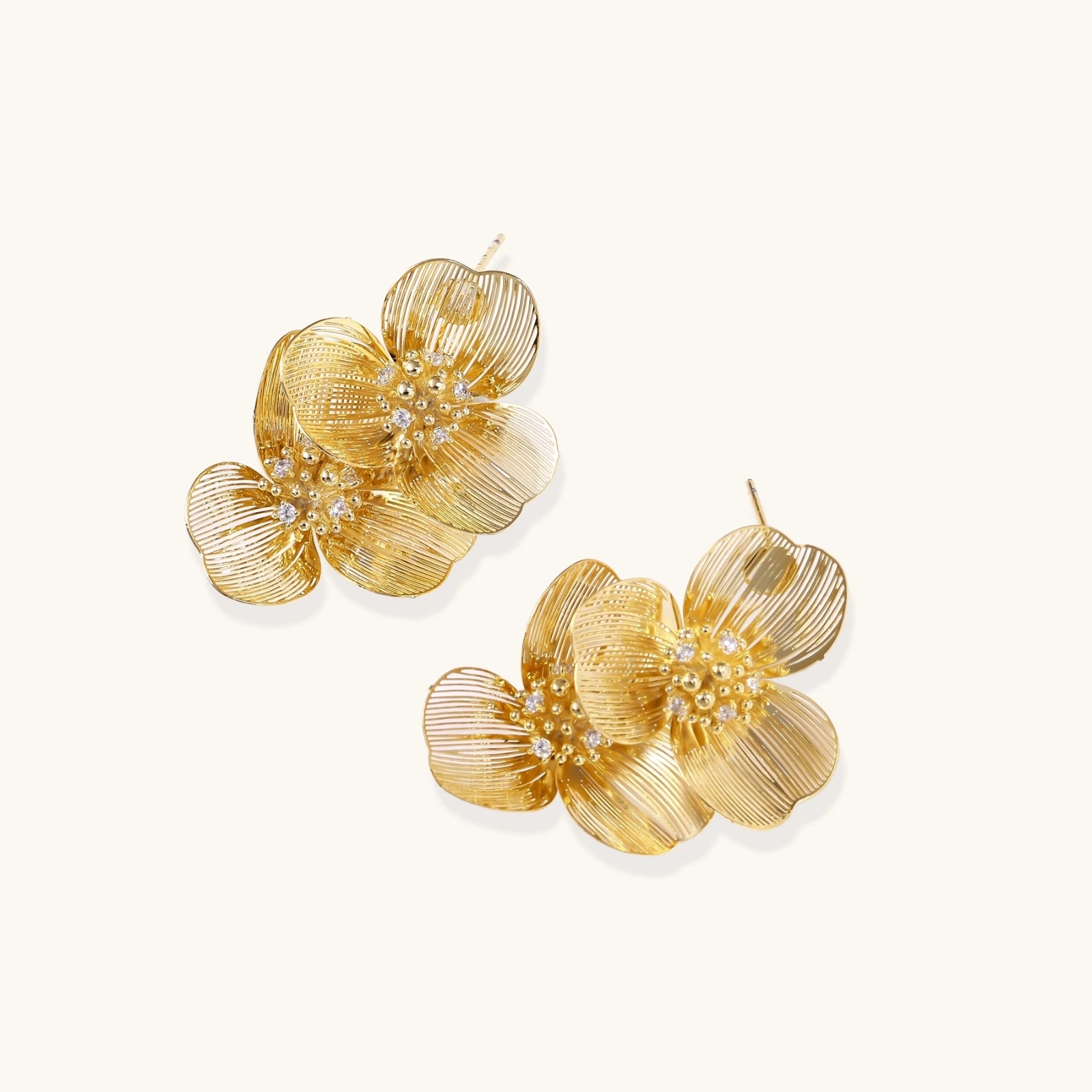Pair of gold floral earrings on a white background