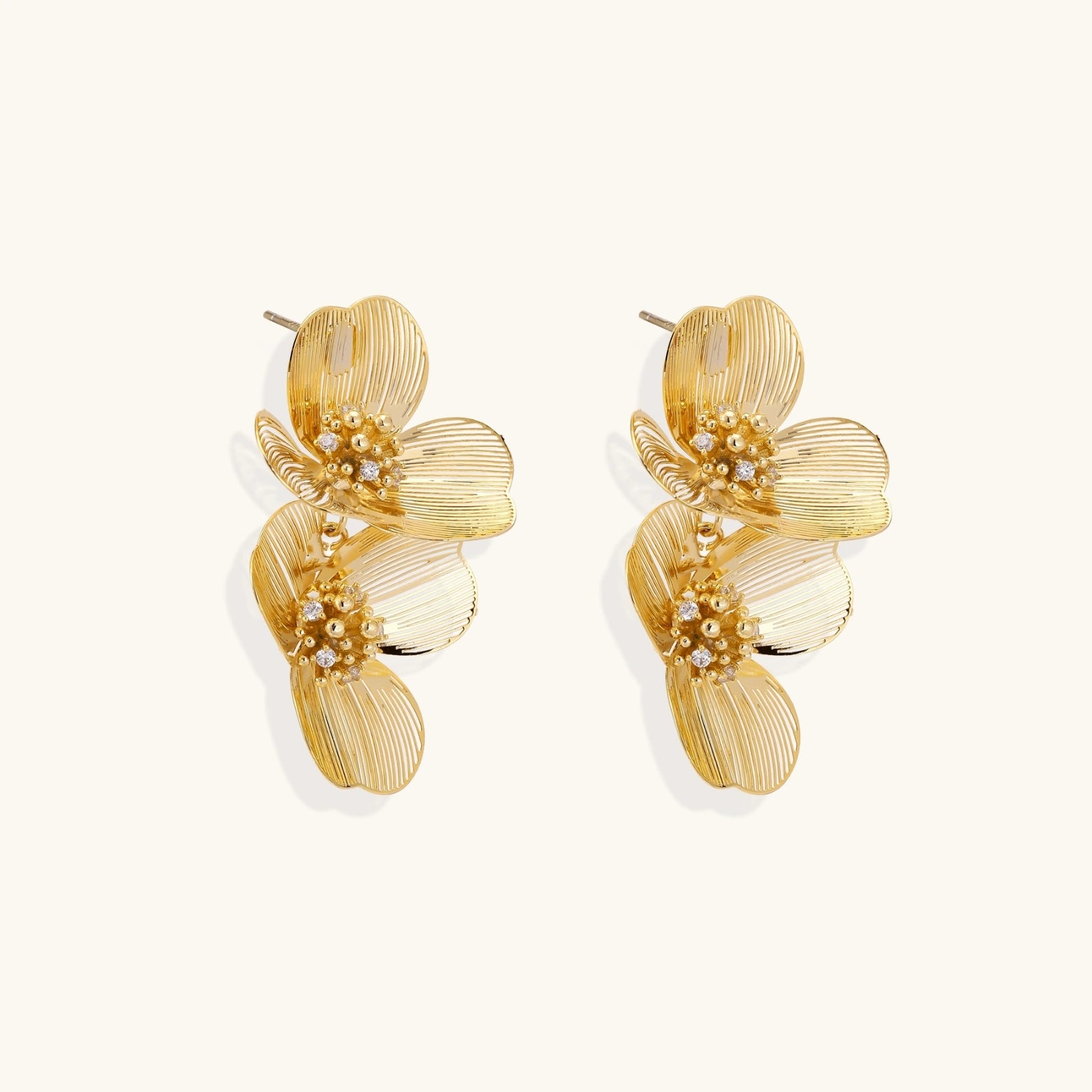 Pair of gold floral earrings on a white background