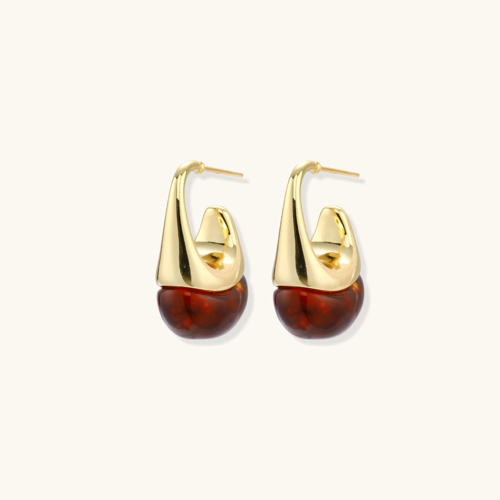 Gold hoop earrings with brown beads on a white background