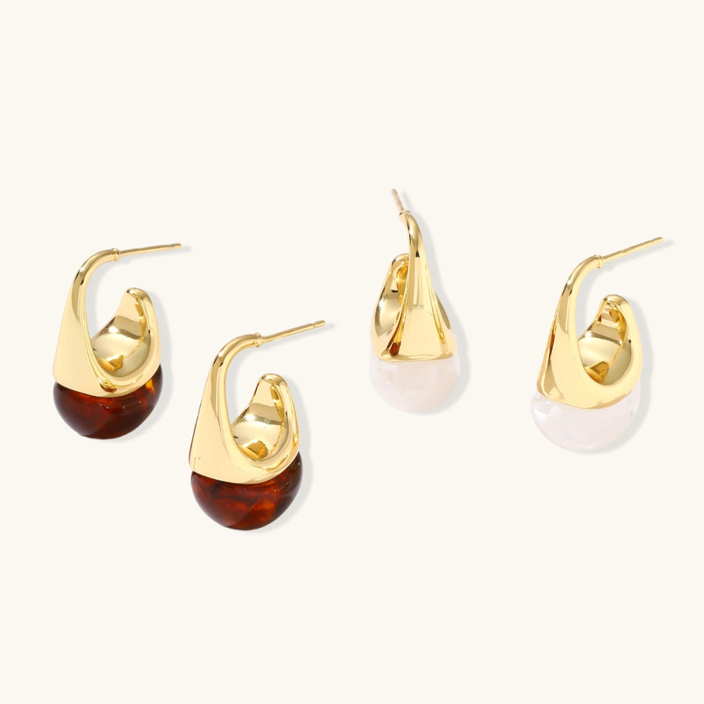 Set of gold and tortoiseshell hoop earrings on a white background