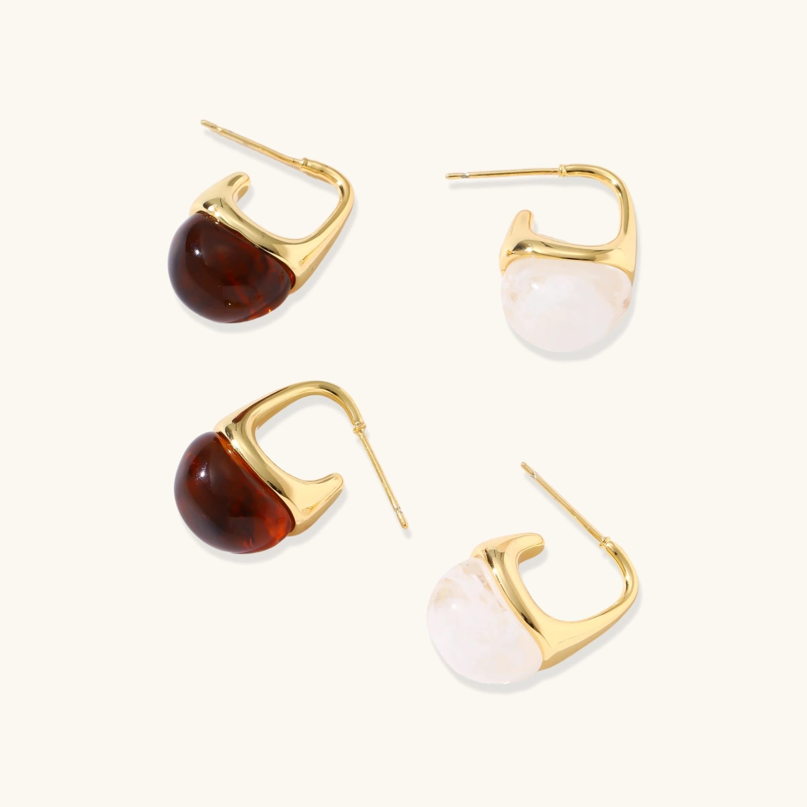 Gold hoop earrings with amber and white stone accents on a white background