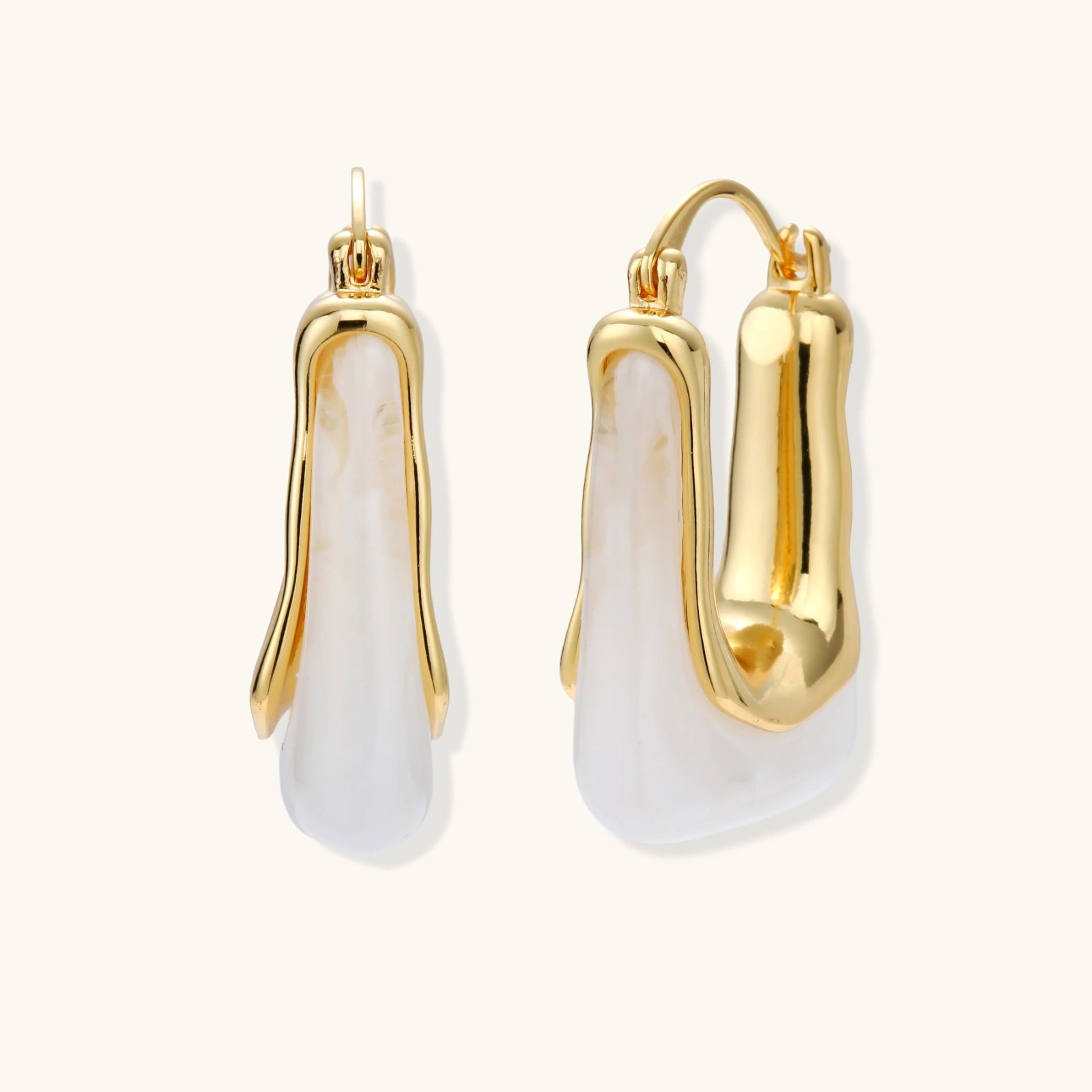 Gold and white earrings on a white background