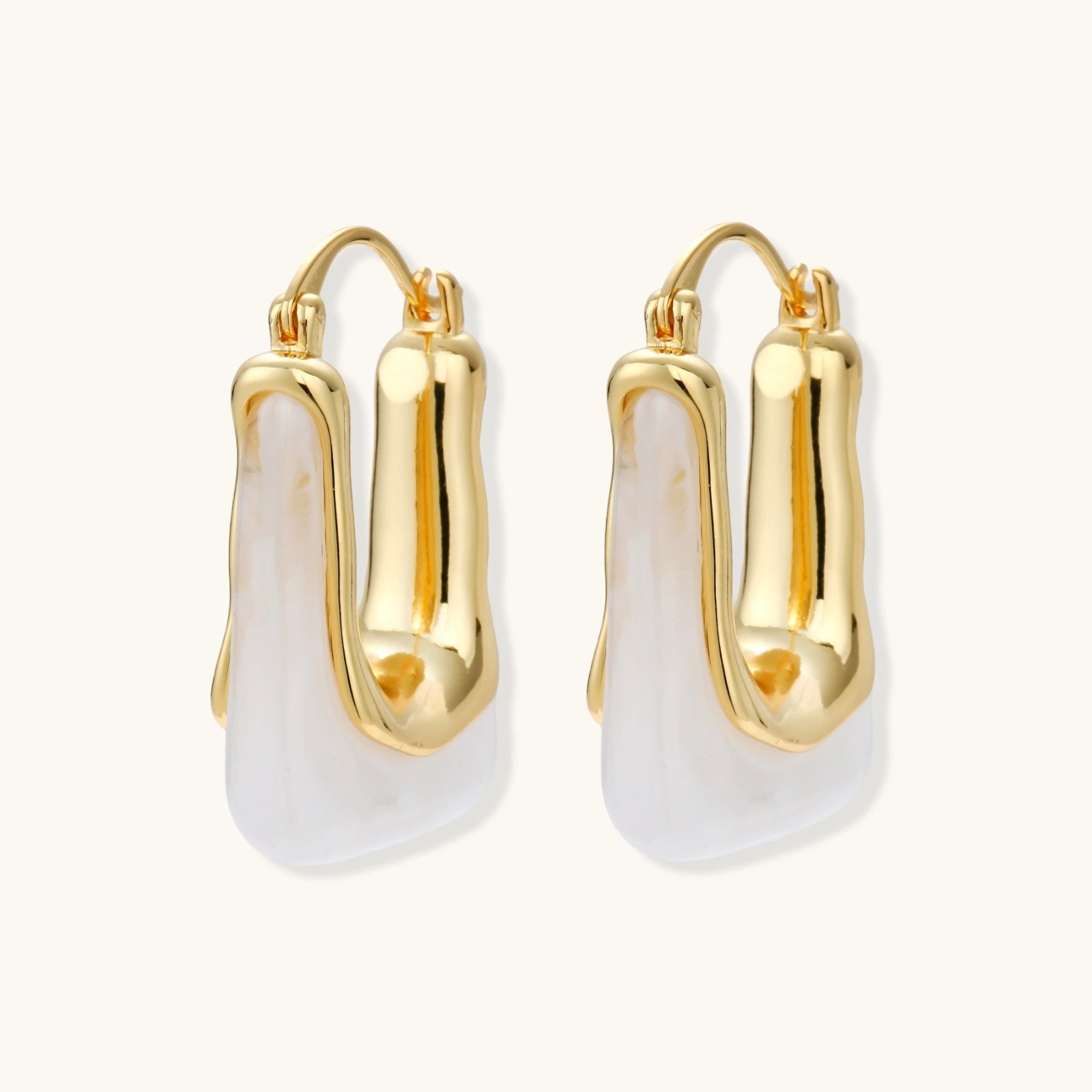 Gold hoop earrings with white stones on a white background
