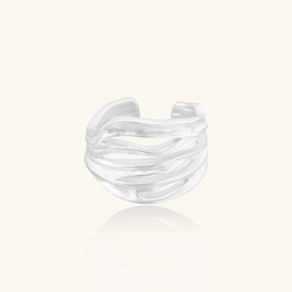 Silver ring with a wavy design on a white background