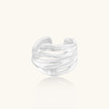 Silver ring with a wavy design on a white background