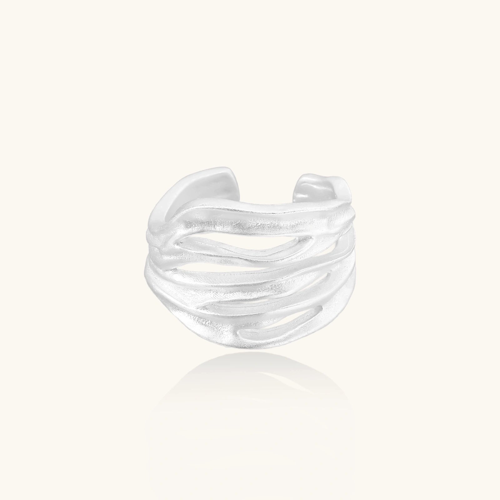 Silver ring with a wavy design on a white background