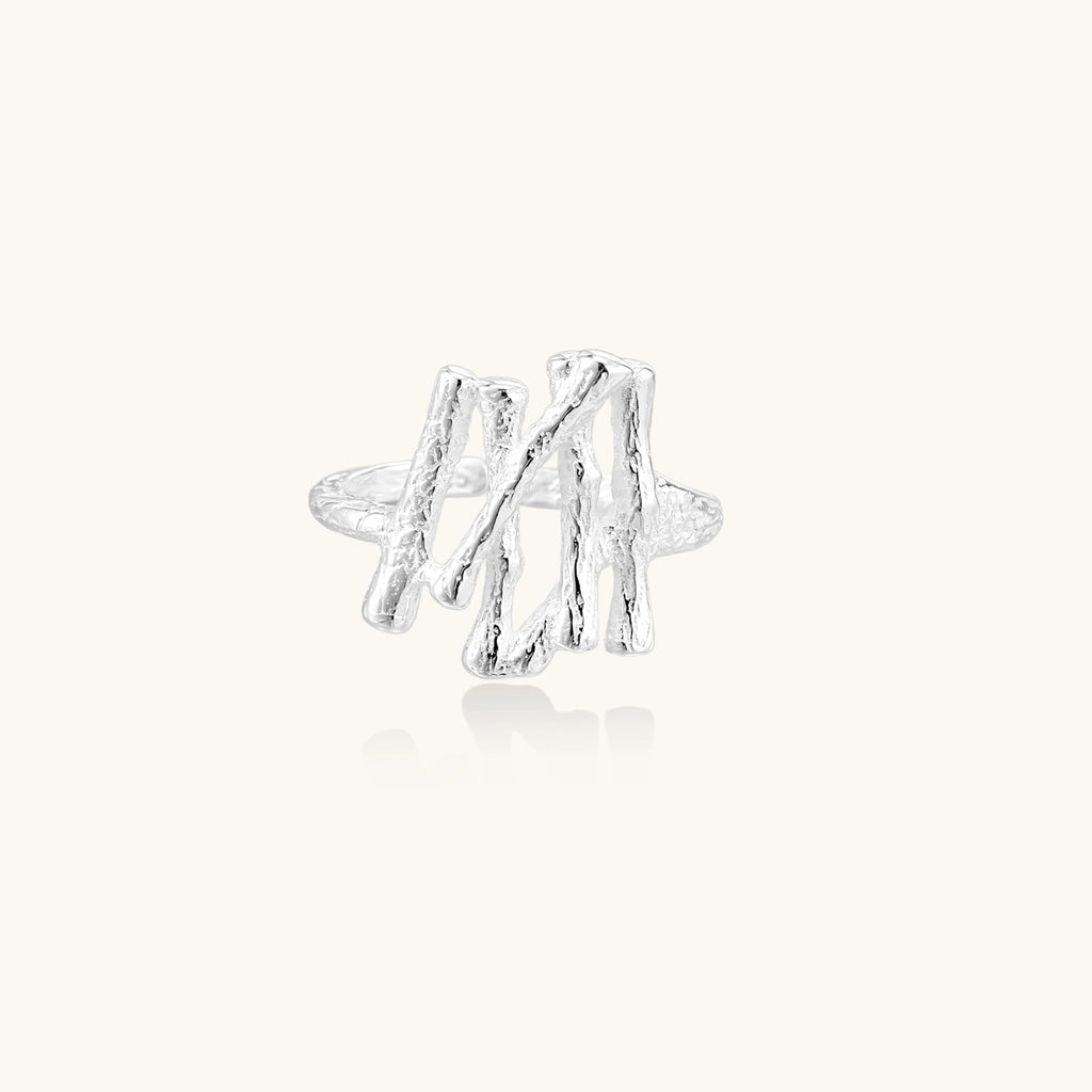 Silver twig-shaped earring on a white background