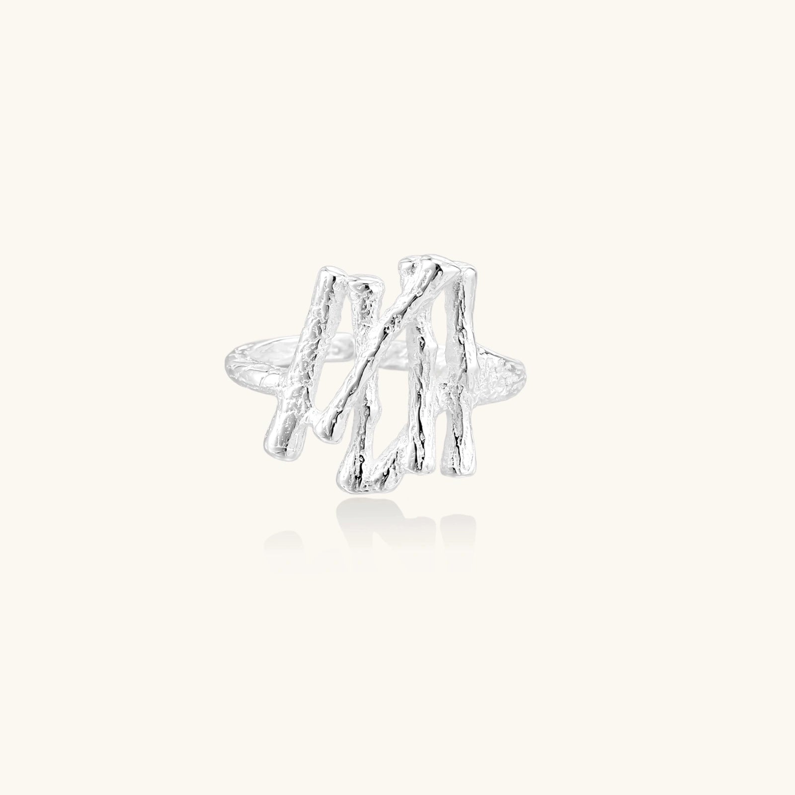 Silver twig-shaped earring on a white background