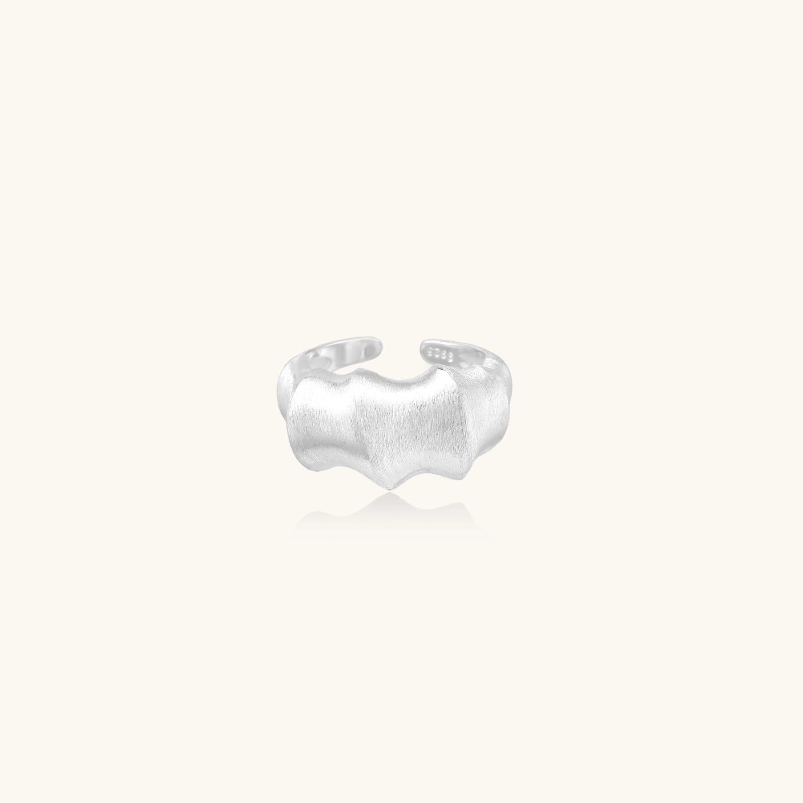 Silver ring with ridge design on a white background