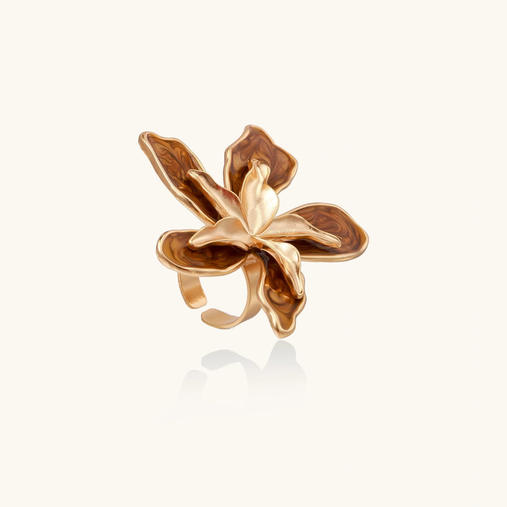 Gold orchid-shaped ring on a white background