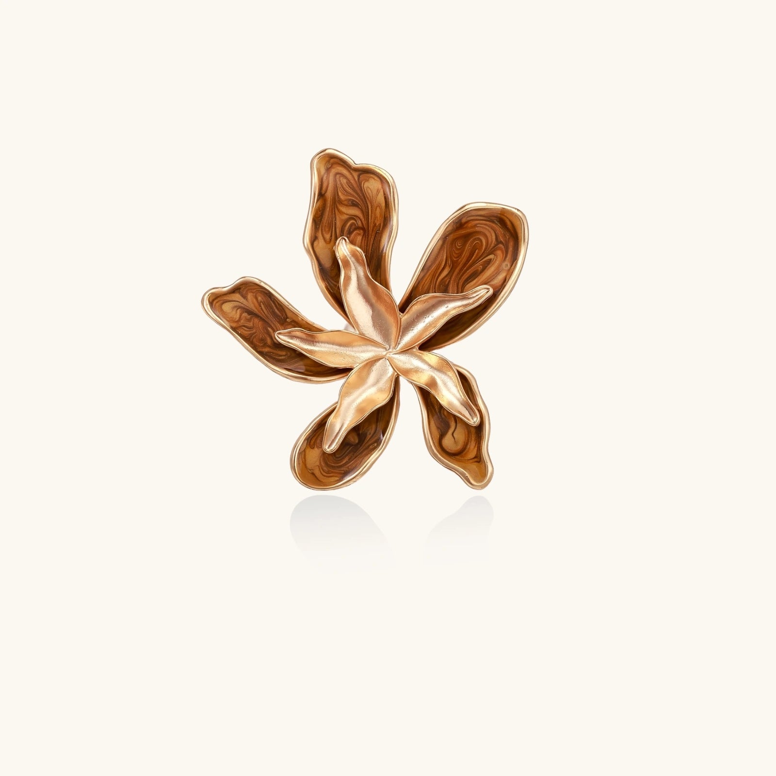 Gold flower-shaped earring on a white background