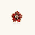 Red flower-shaped crystal statement ring with gold accents on a white background
