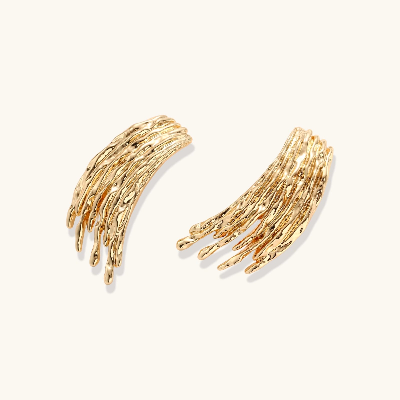 Gold branch-like earrings on a white background