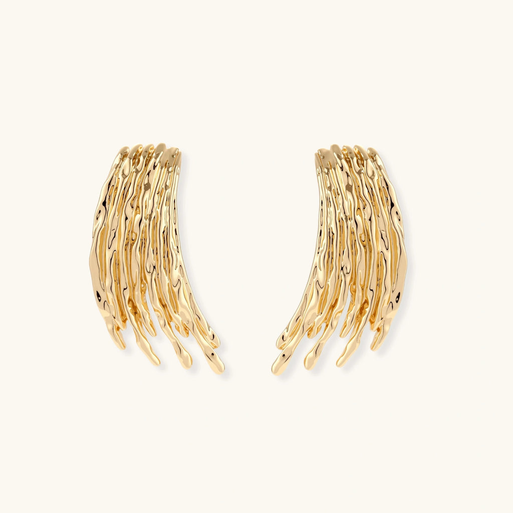 Gold wing-shaped earrings on a white background