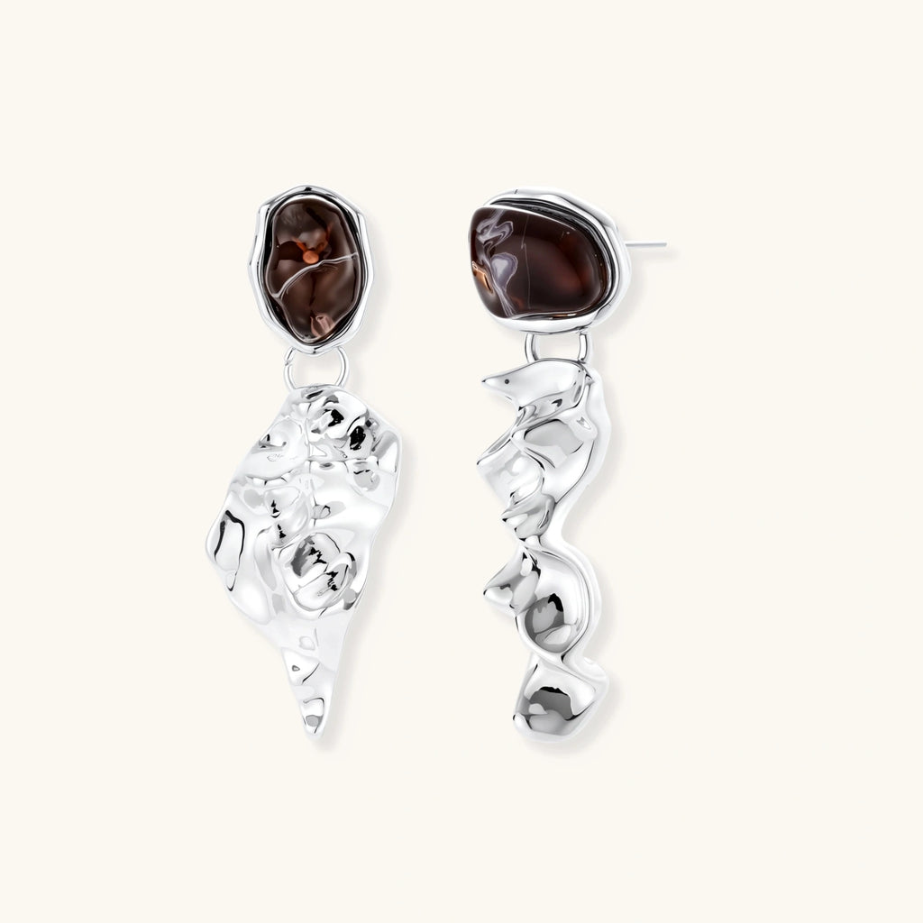 Pair of silver earrings with brown gemstones on a white background