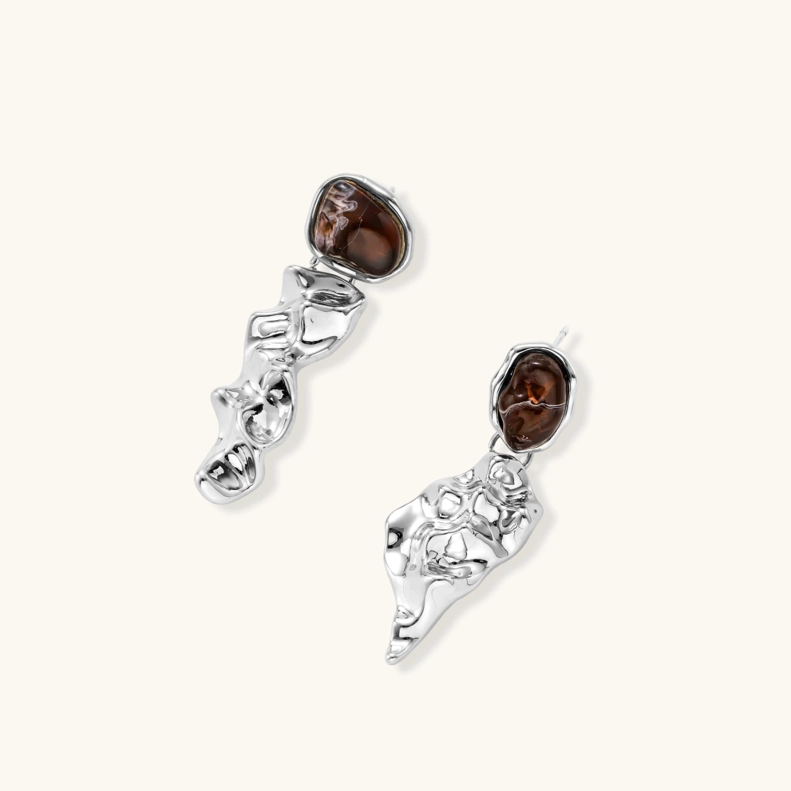 Pair of silver earrings with brown gemstones on a white background