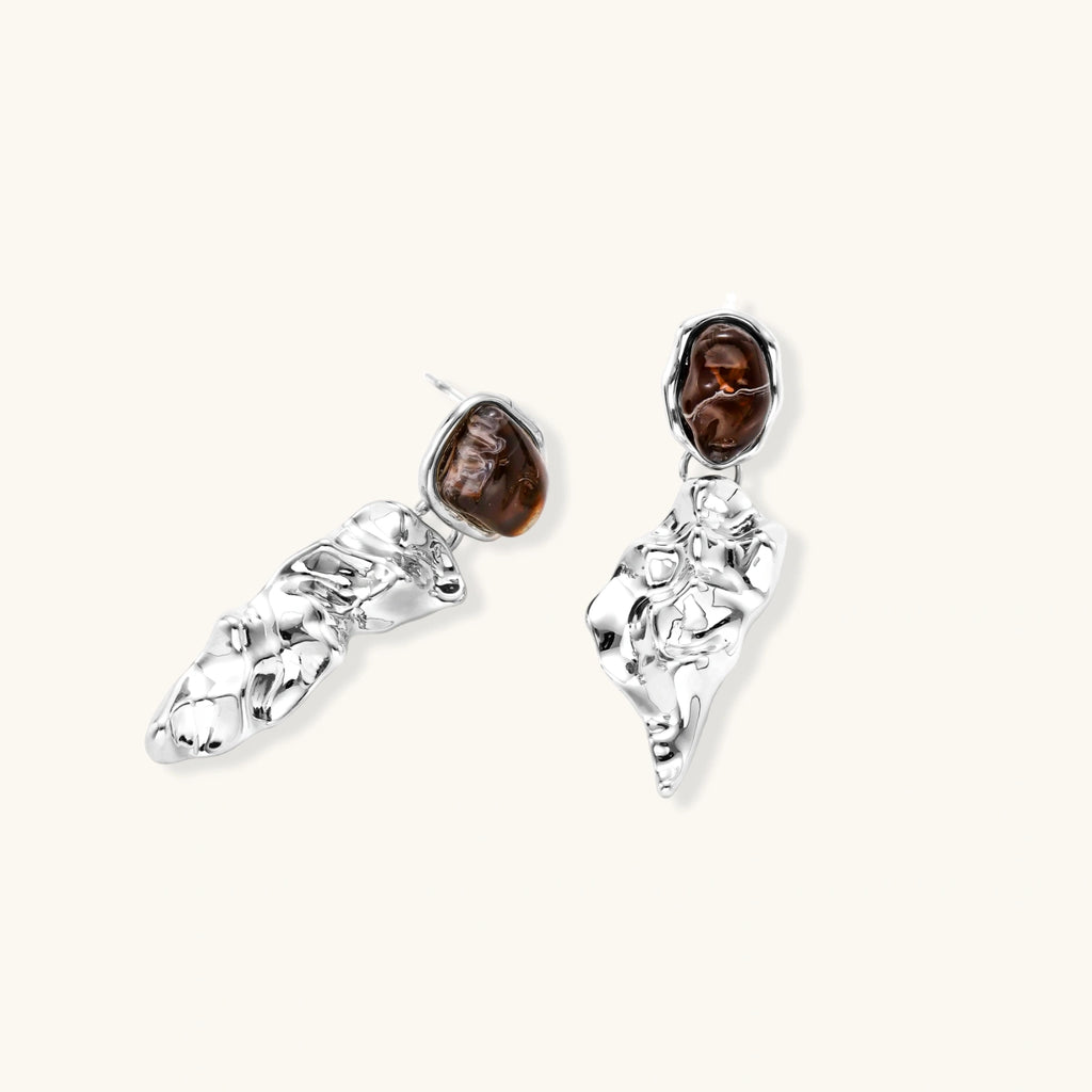 Pair of silver earrings with brown gemstones on a white background