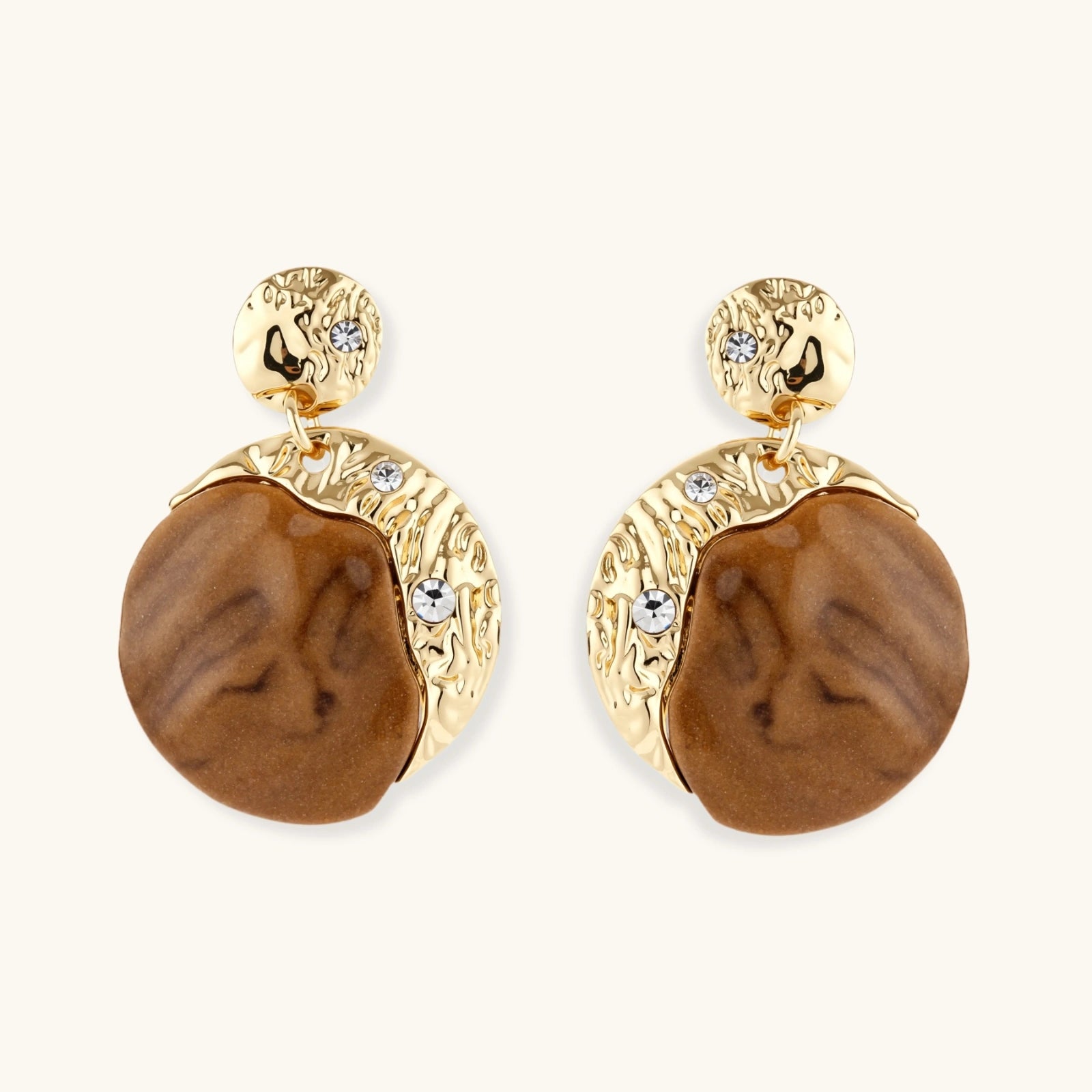Pair of earrings with gold and brown design on a white background