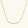 Gold necklace with small diamond-like pendants on a white background