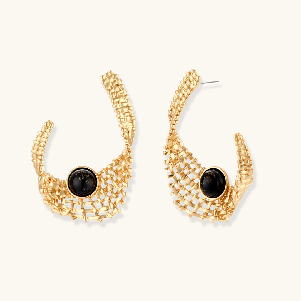 Gold hoop earrings with black gemstones on a white background
