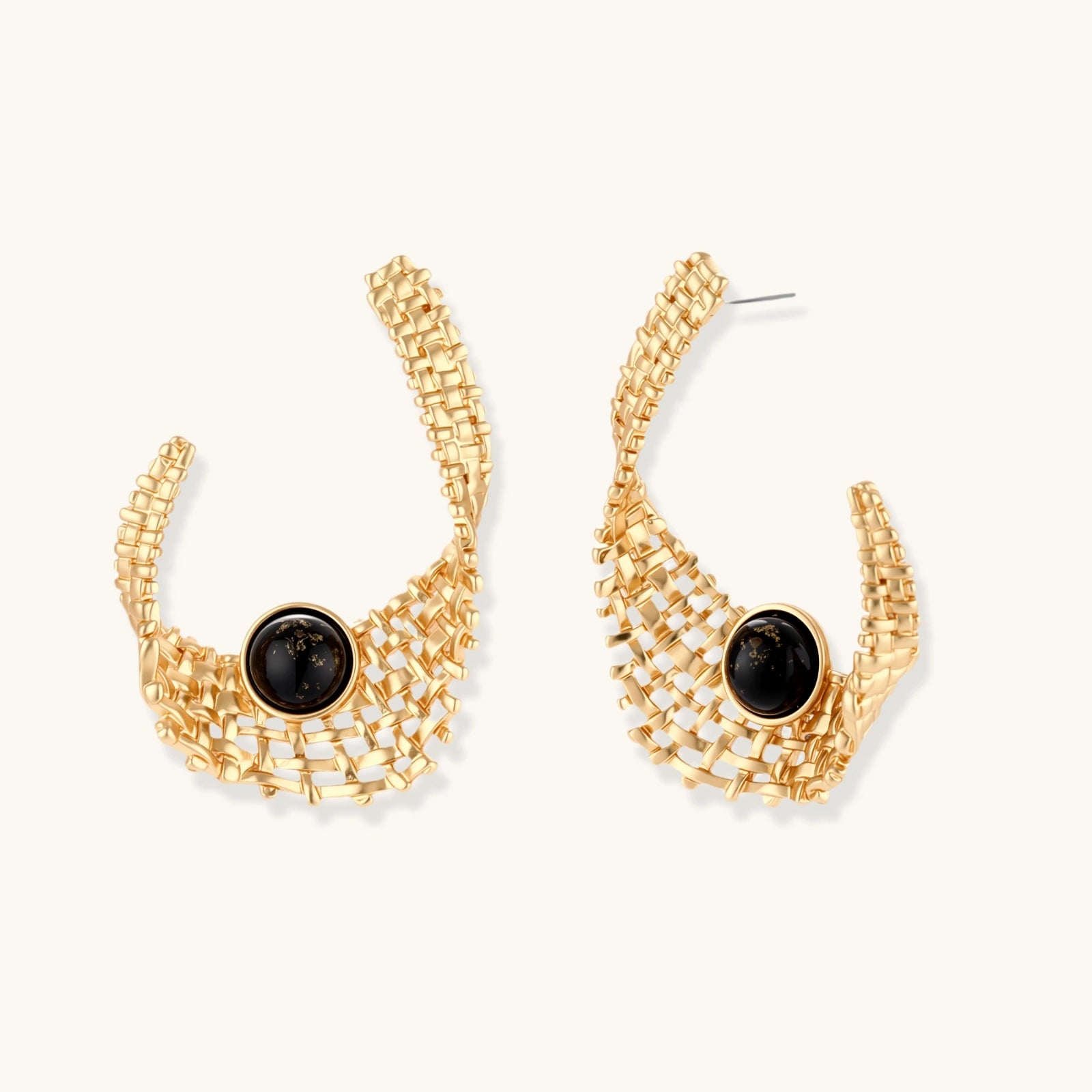 Gold hoop earrings with black gemstones on a white background