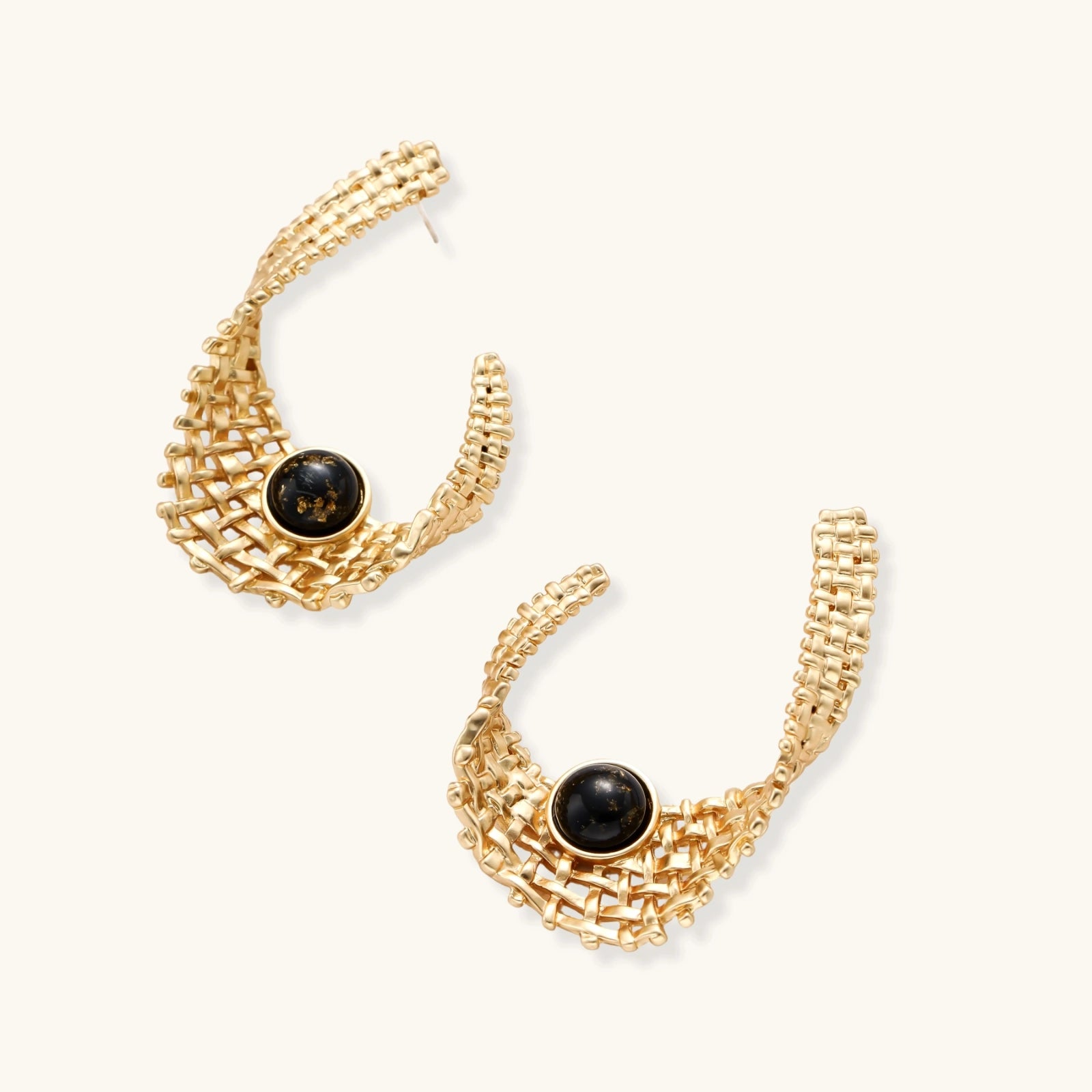 Gold hoop earrings with black gemstones on a white background