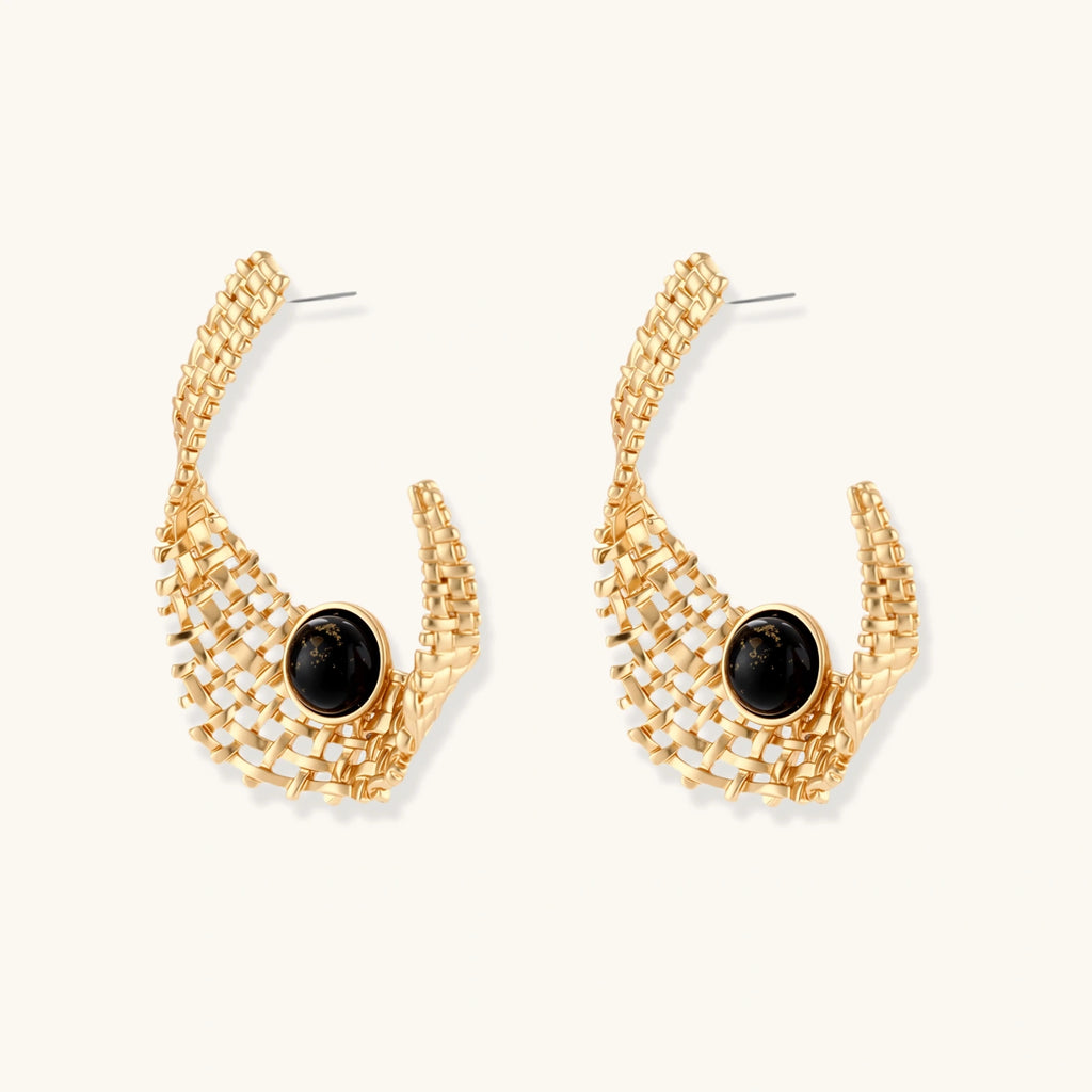 Gold hoop earrings with black gemstones on a white background