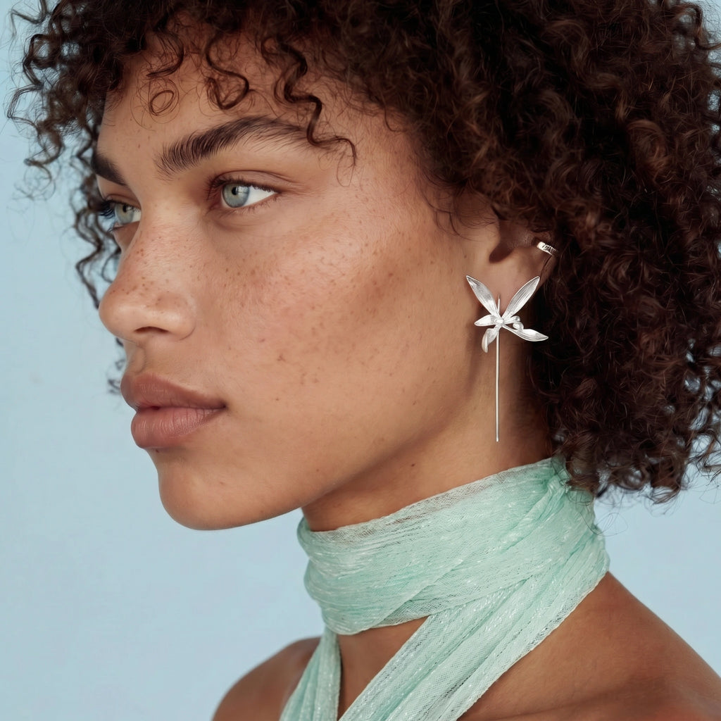 Close-up of a woman wearing a sterling silver floral earring 