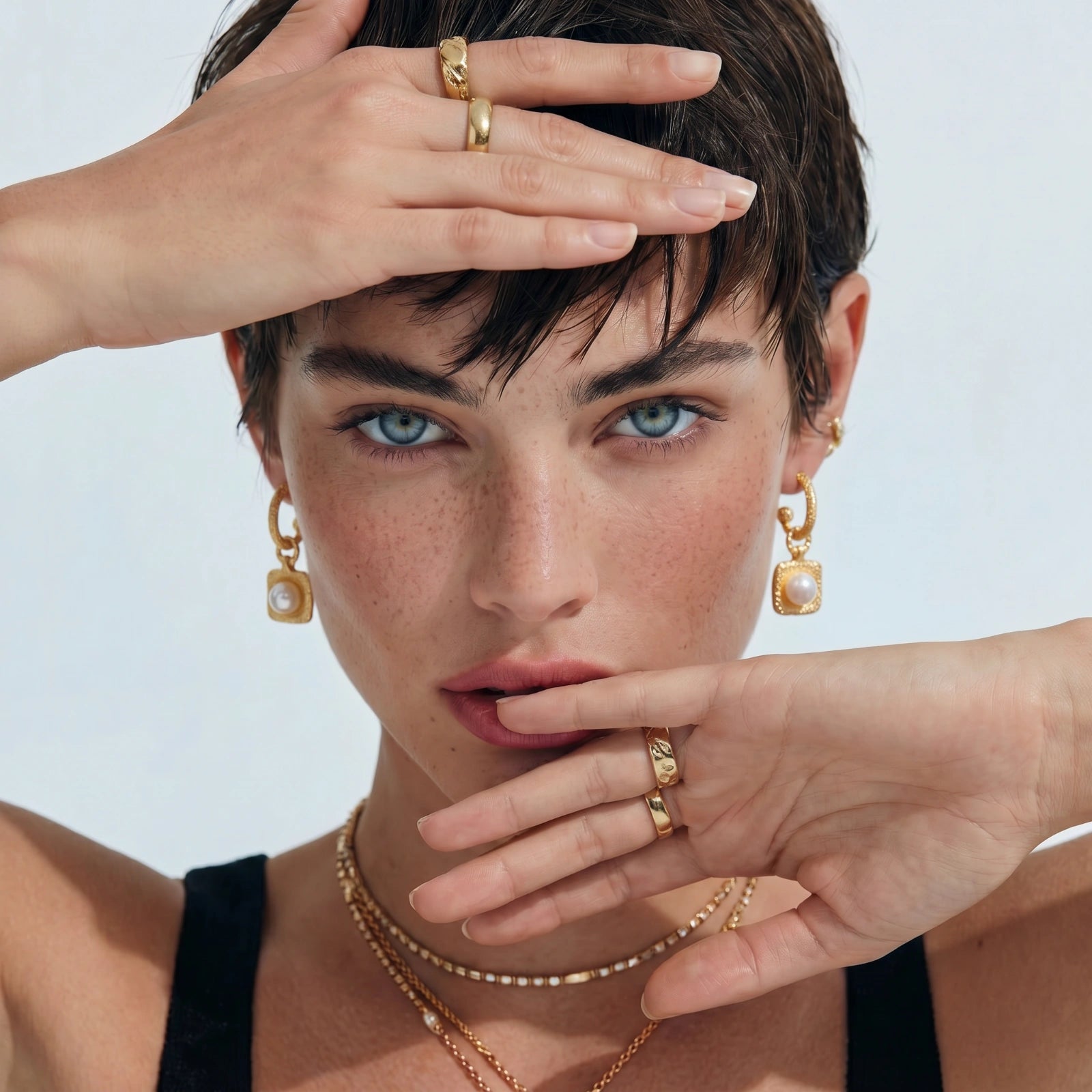 Woman wearing gold jewelry with a plain background