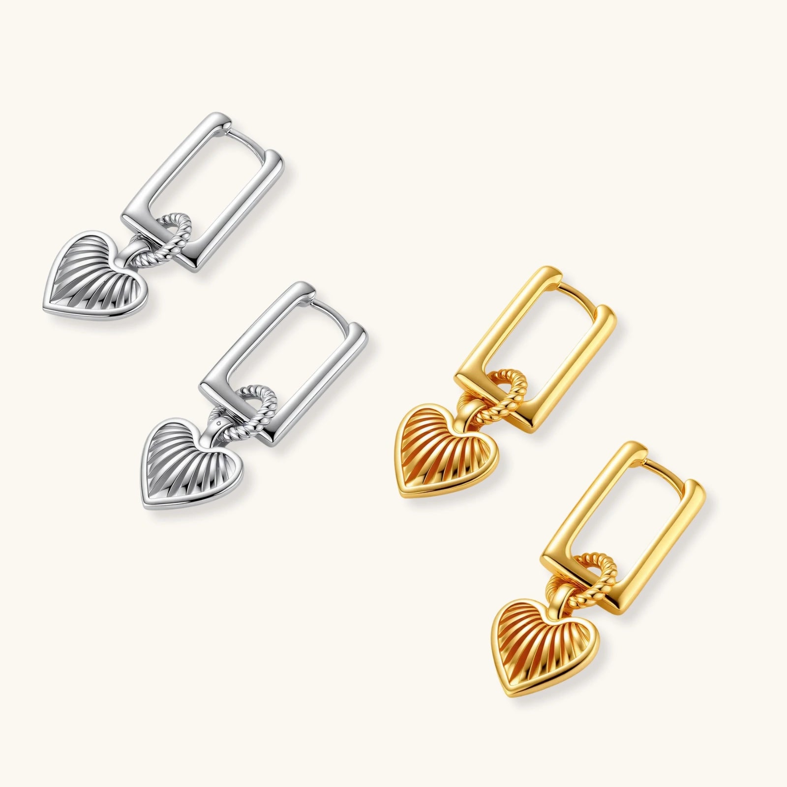 Pair of silver and gold heart-shaped earrings on a white background