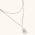 Silver necklace with a clear pendant on a white background