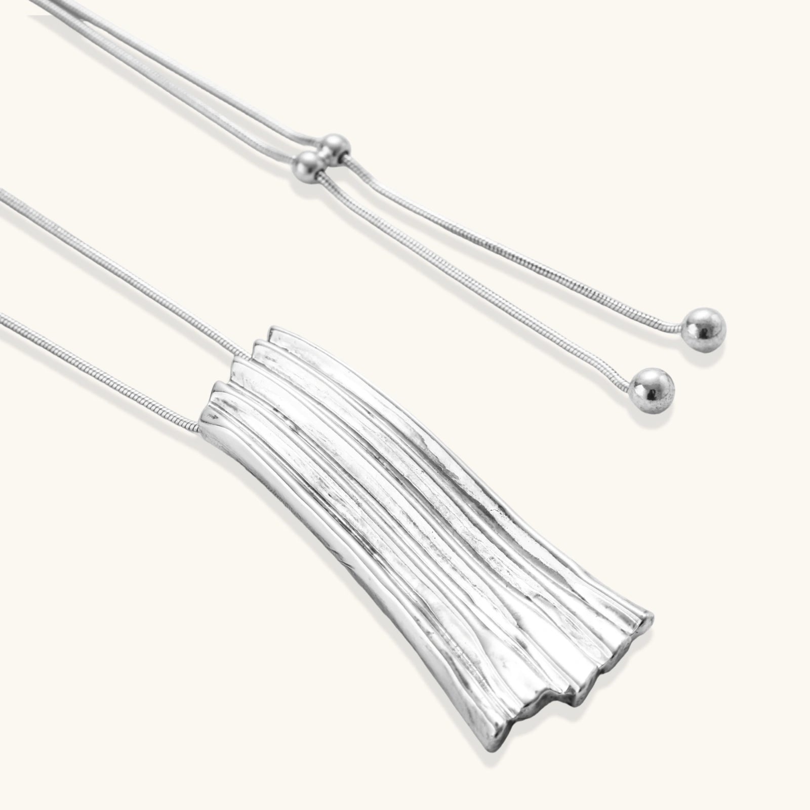 Silver tassel necklace on a white background