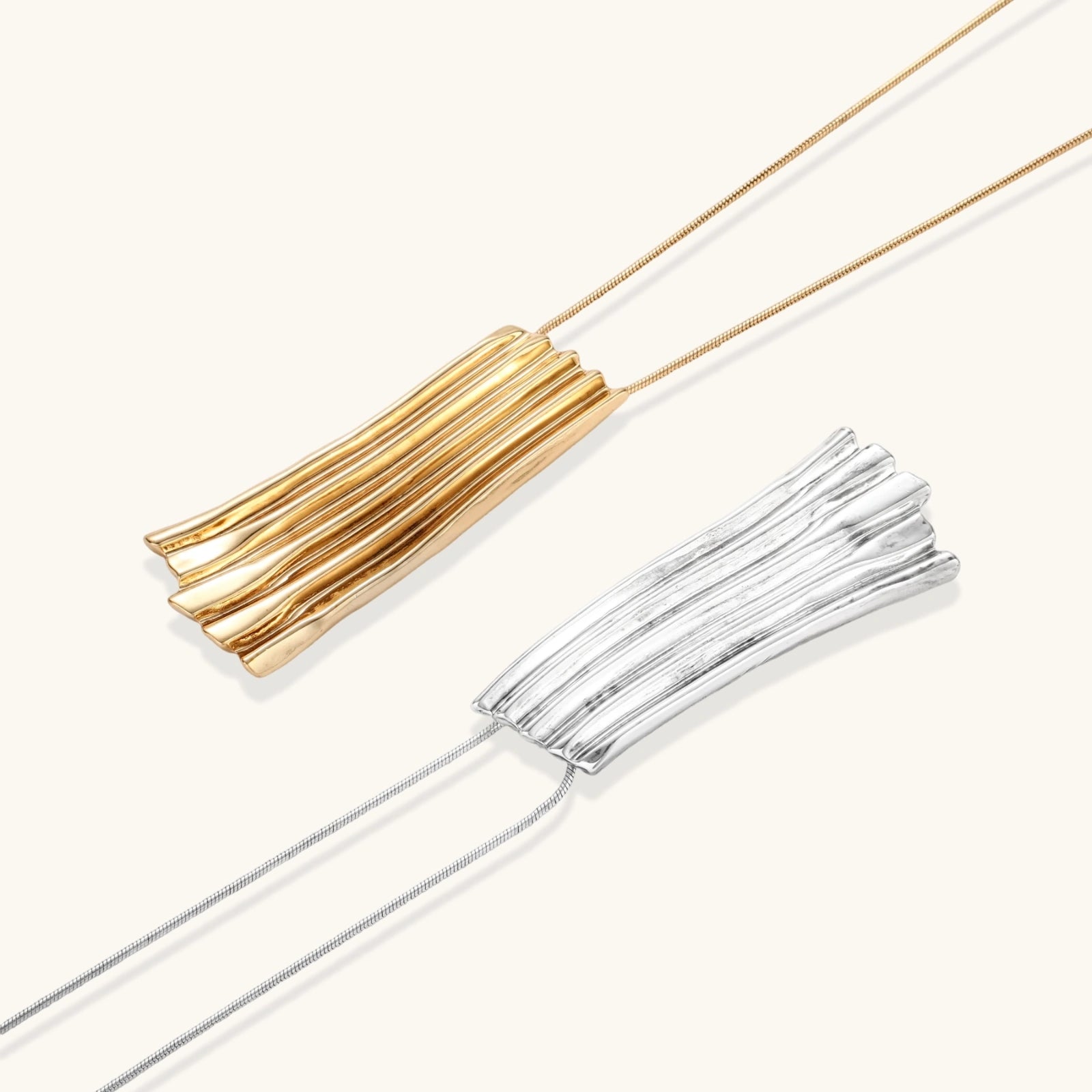Gold and silver tassel necklaces on a white background