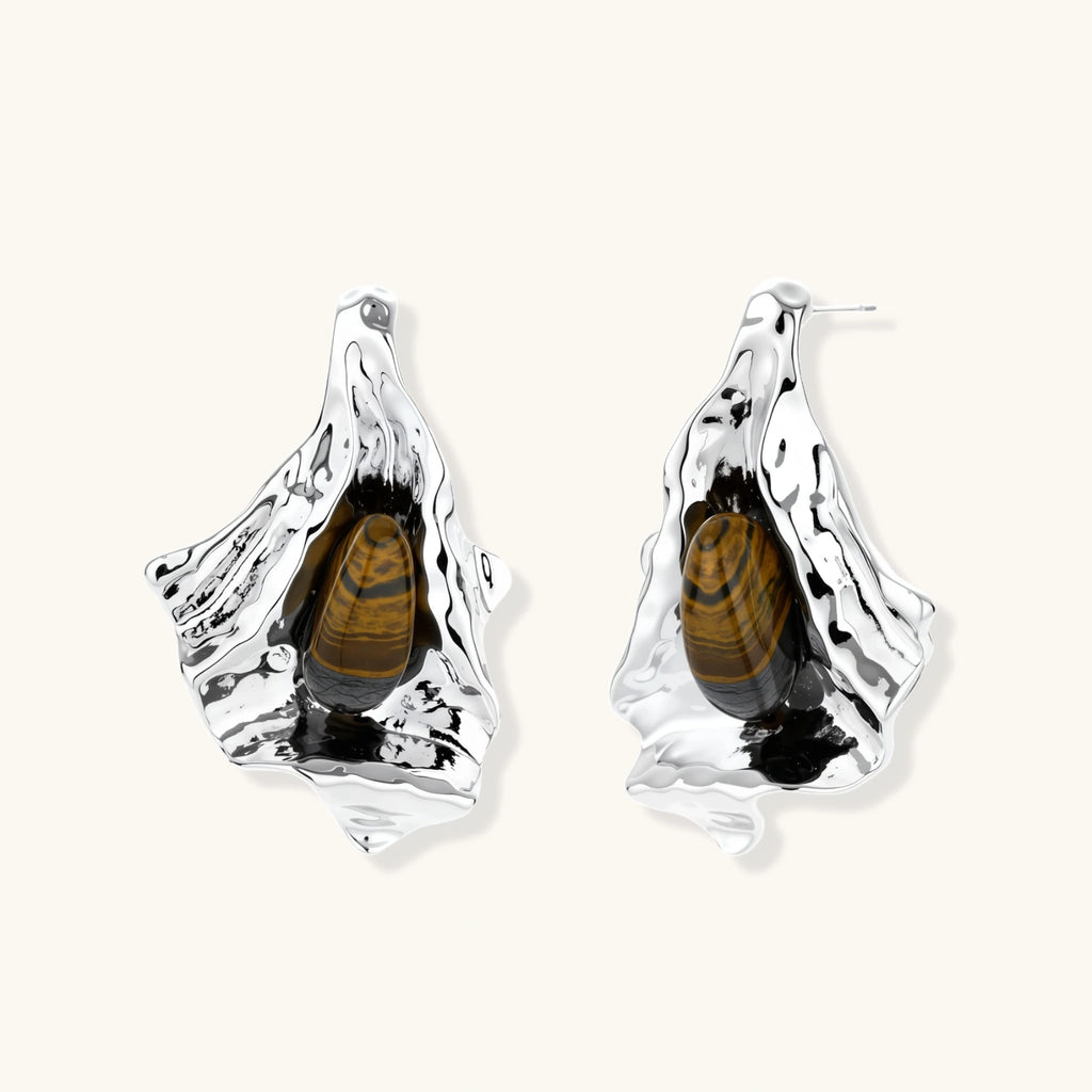Silver earrings with embedded beetles on a white background