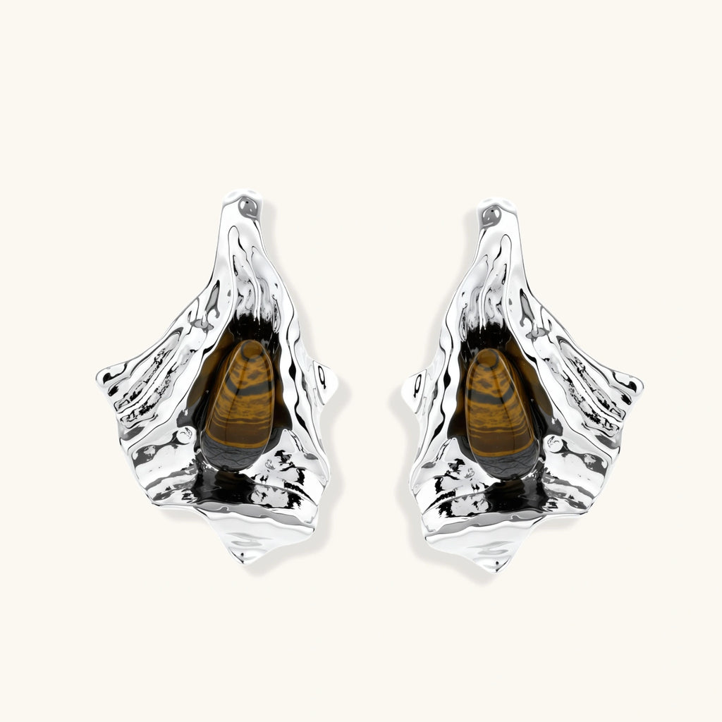 Pair of silver earrings with a central brown gemstone on a white background