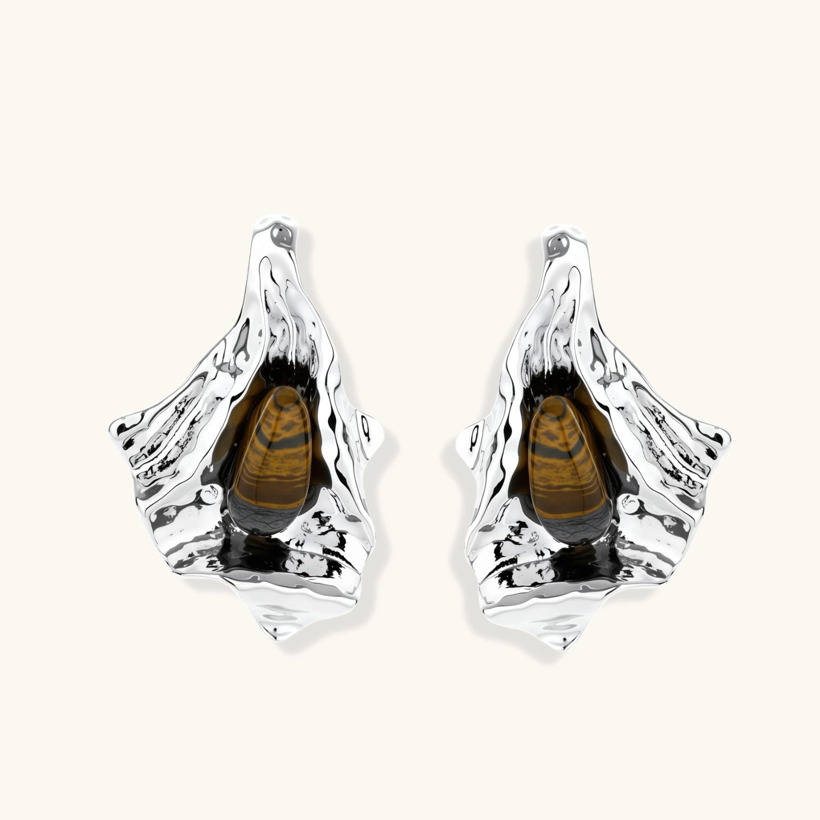 Pair of silver earrings with a central brown gemstone on a white background