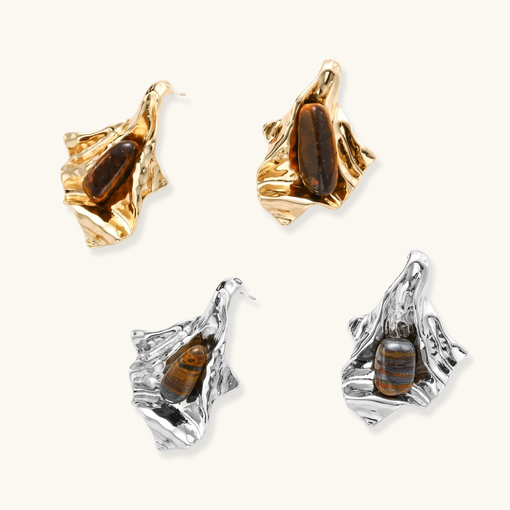 Pair of gold and silver earrings with embedded stones on a white background