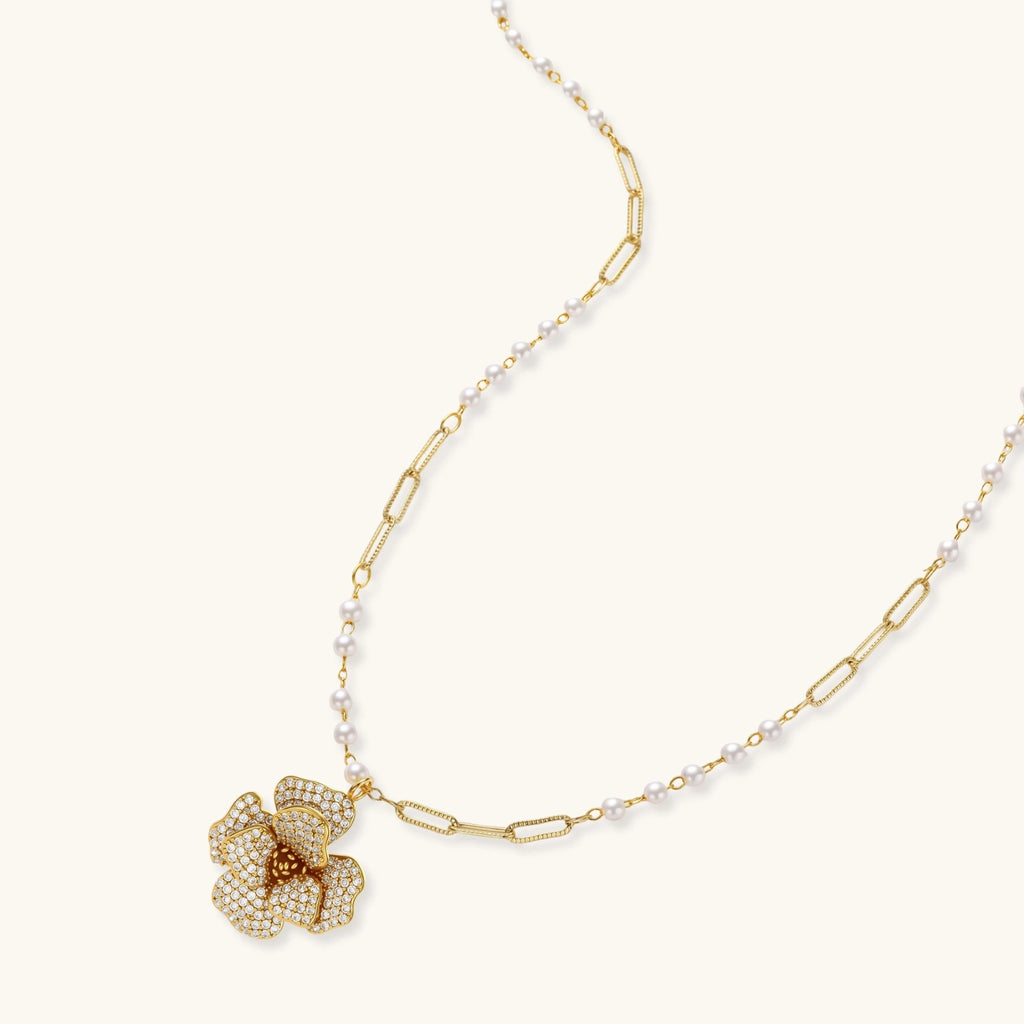 Gold necklace with a floral pendant on a white background